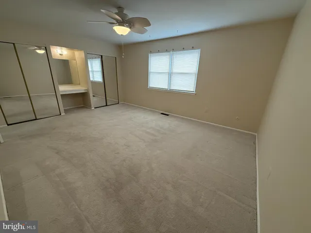 an empty room with a fireplace and windows