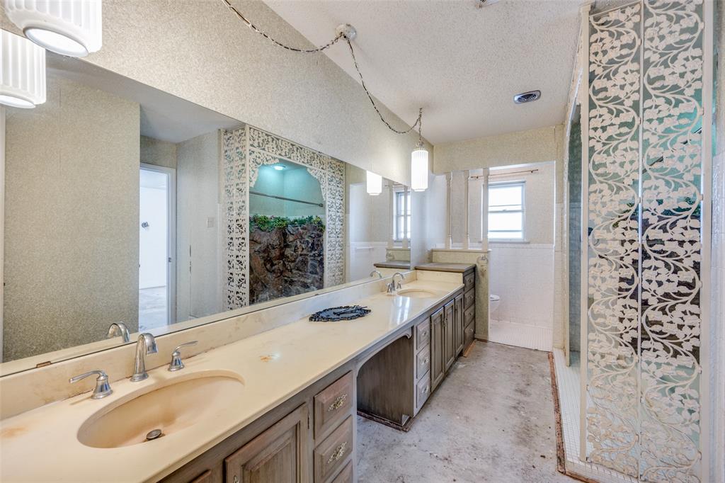 5001 Boulder Lake Road Fort Worth, TX 76103 - Photo 19 of 22 a spacious bathroom with a granite countertop sink a mirror and a shower