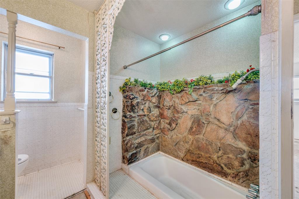 5001 Boulder Lake Road Fort Worth, TX 76103 - Photo 20 of 22 a bathroom with a shower curtain and a window