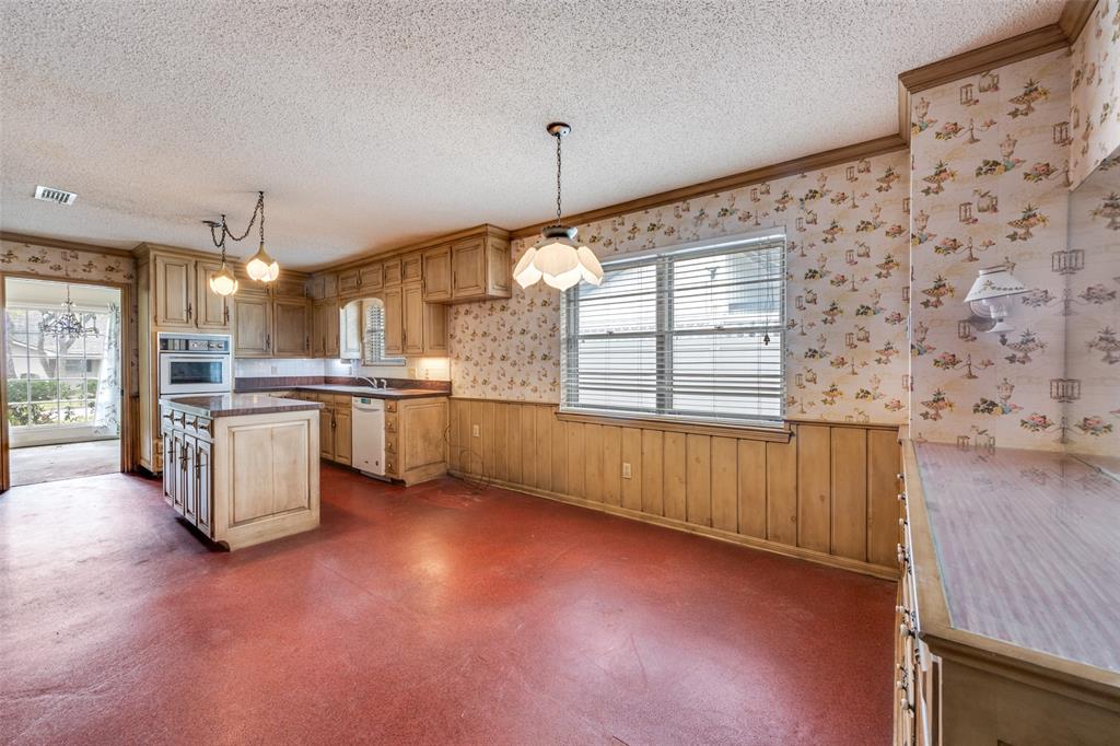 5001 Boulder Lake Road Fort Worth, TX 76103 - Photo 7 of 22 a kitchen with stainless steel appliances kitchen island granite countertop a stove a sink a refrigerator white cabinets and wooden floor