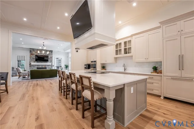 a kitchen with stainless steel appliances kitchen island granite countertop a table chairs sink and cabinets