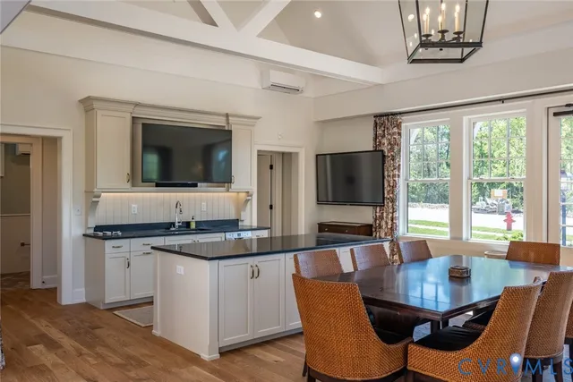 a kitchen with granite countertop a stove a sink a dining table and chairs
