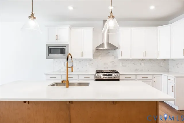 a kitchen with stainless steel appliances a sink a stove a microwave and cabinets