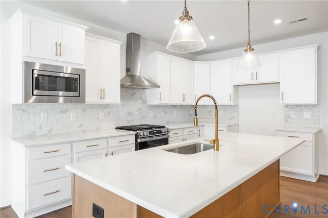 a kitchen with stainless steel appliances a stove a sink a microwave and cabinets