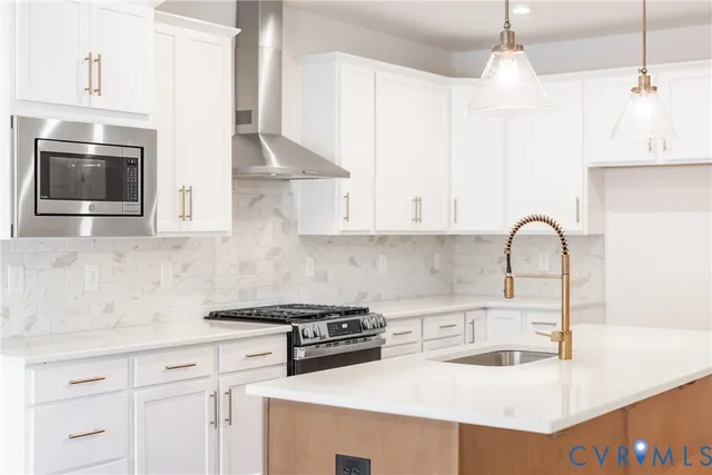 a kitchen with stainless steel appliances granite countertop a sink a stove and a microwave