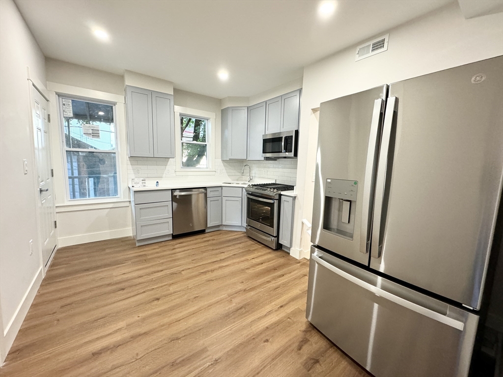 a kitchen with stainless steel appliances granite countertop a refrigerator and a stove