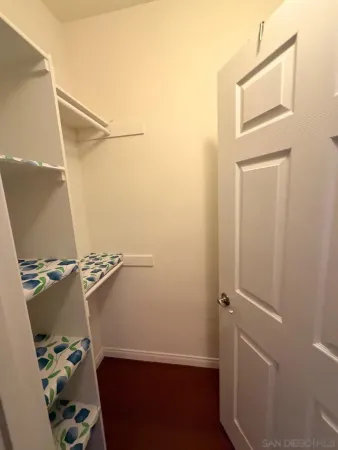 a view of walk in closet with clothes and shoes