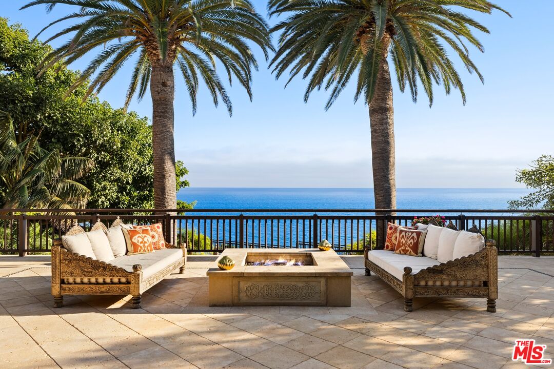 24834 Pacific Coast Highway Malibu, CA 90265 - Photo 13 of 50 a view of swimming pool with a couches and palm trees