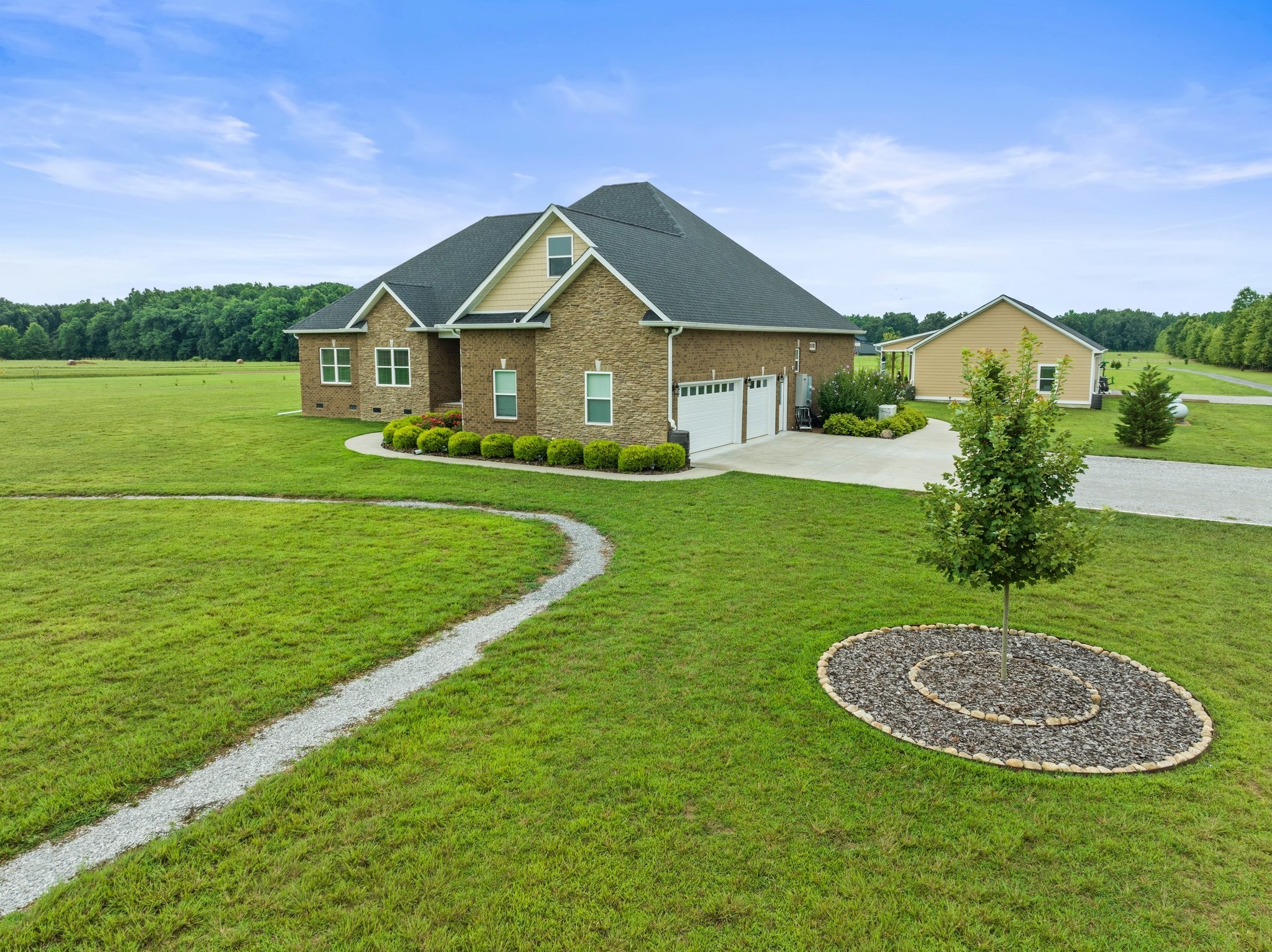 a view of a big house with a big yard and potted plants in front of the house