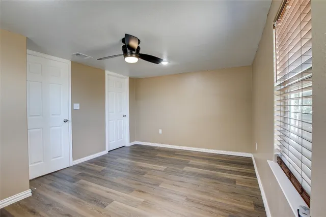 a view of room with hardwood floor and ceiling fan