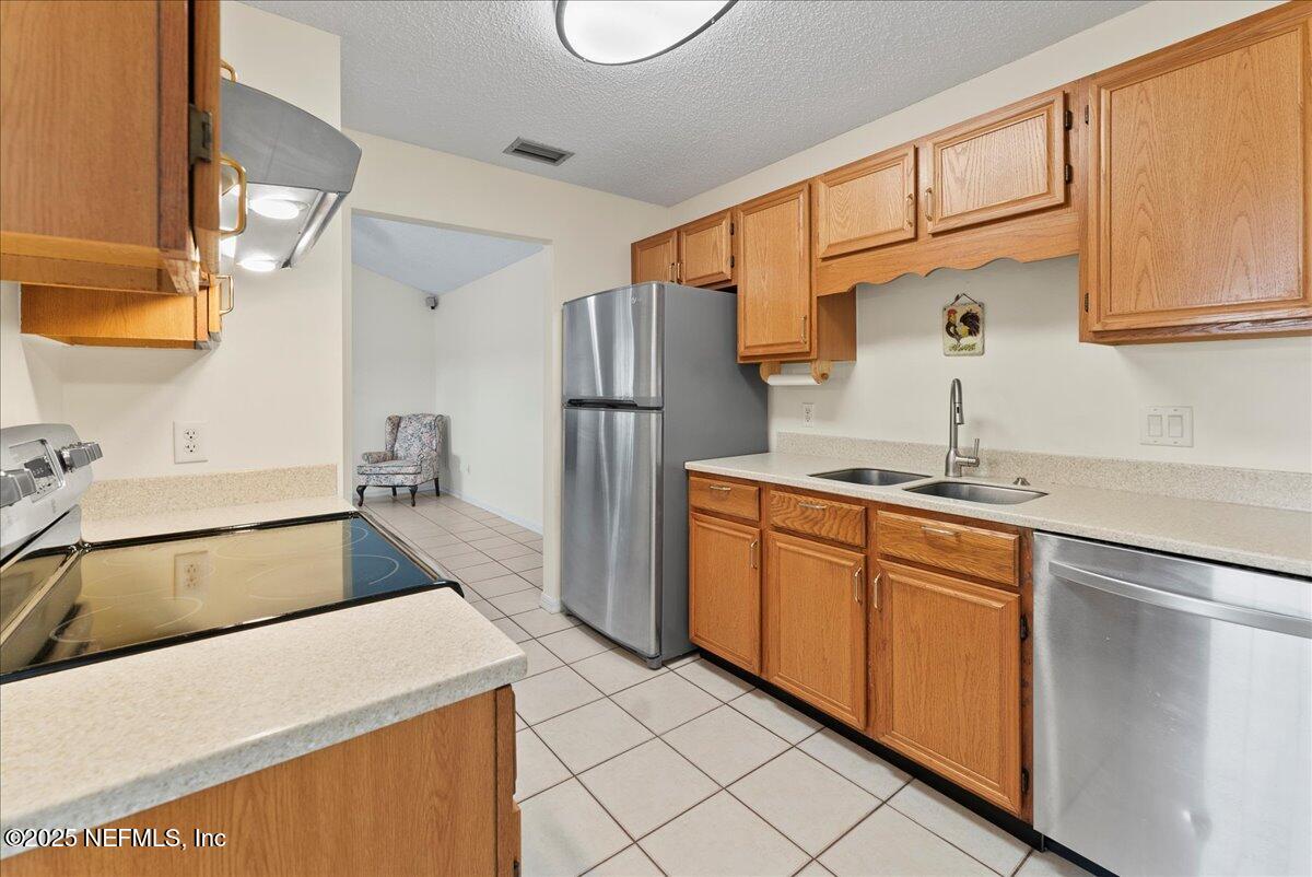 210 Dartmouth Road St. Augustine, FL 32086 - Photo 11 of 27 a kitchen with a refrigerator sink and cabinets