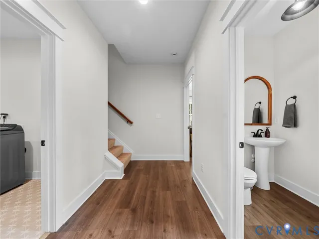 a view of a hallway with wooden floor and staircase
