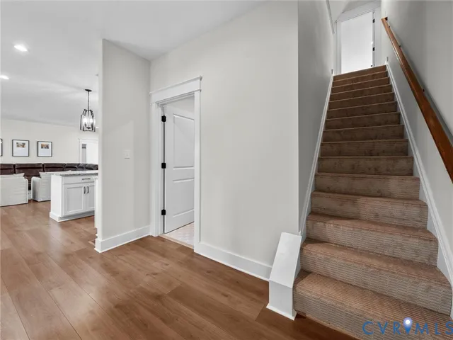 a view of an entryway with wooden floor and stairs
