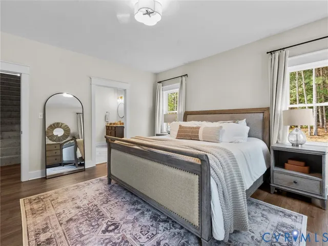 a bedroom with a bed and a mirror on the dresser