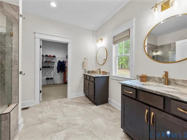 a en suite bathroom with a granite countertop sink a mirror and a vanity