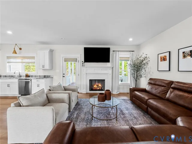 a living room with furniture a flat screen tv and a fireplace