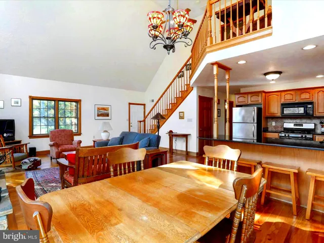 a living room with furniture large window and wooden floor