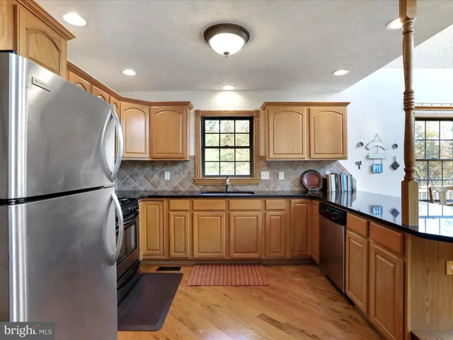 a kitchen with granite countertop a refrigerator and a stove top oven