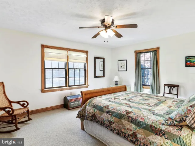 a bedroom with a bed ceiling fan and a window