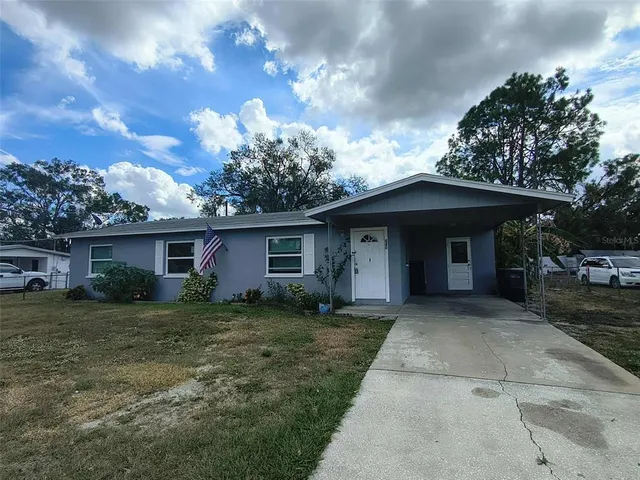 a front view of house with yard and trees all around