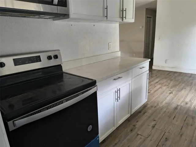 a kitchen with granite countertop a stove and a microwave
