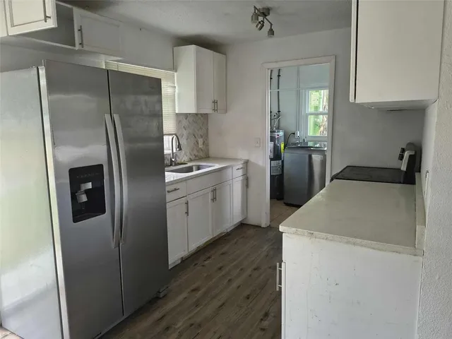 a kitchen with a sink refrigerator and cabinets