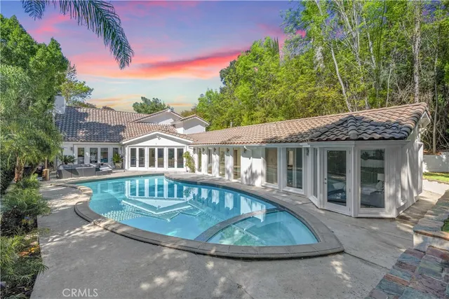a view of swimming pool with lawn chairs and plants