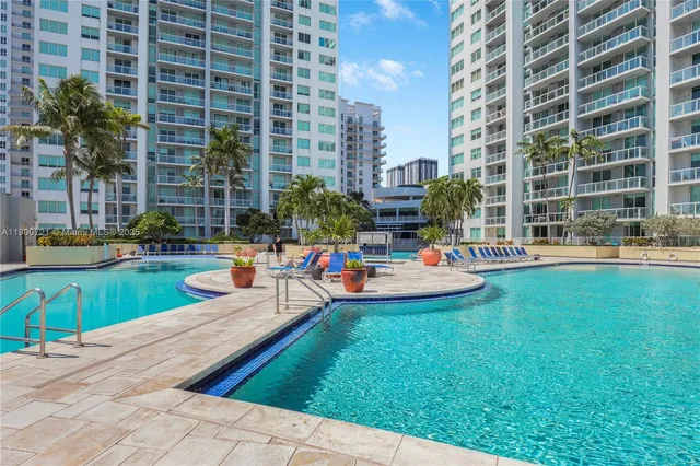 a view of a swimming pool with a bench and tables