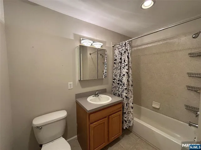 a bathroom with a granite countertop sink a toilet and shower