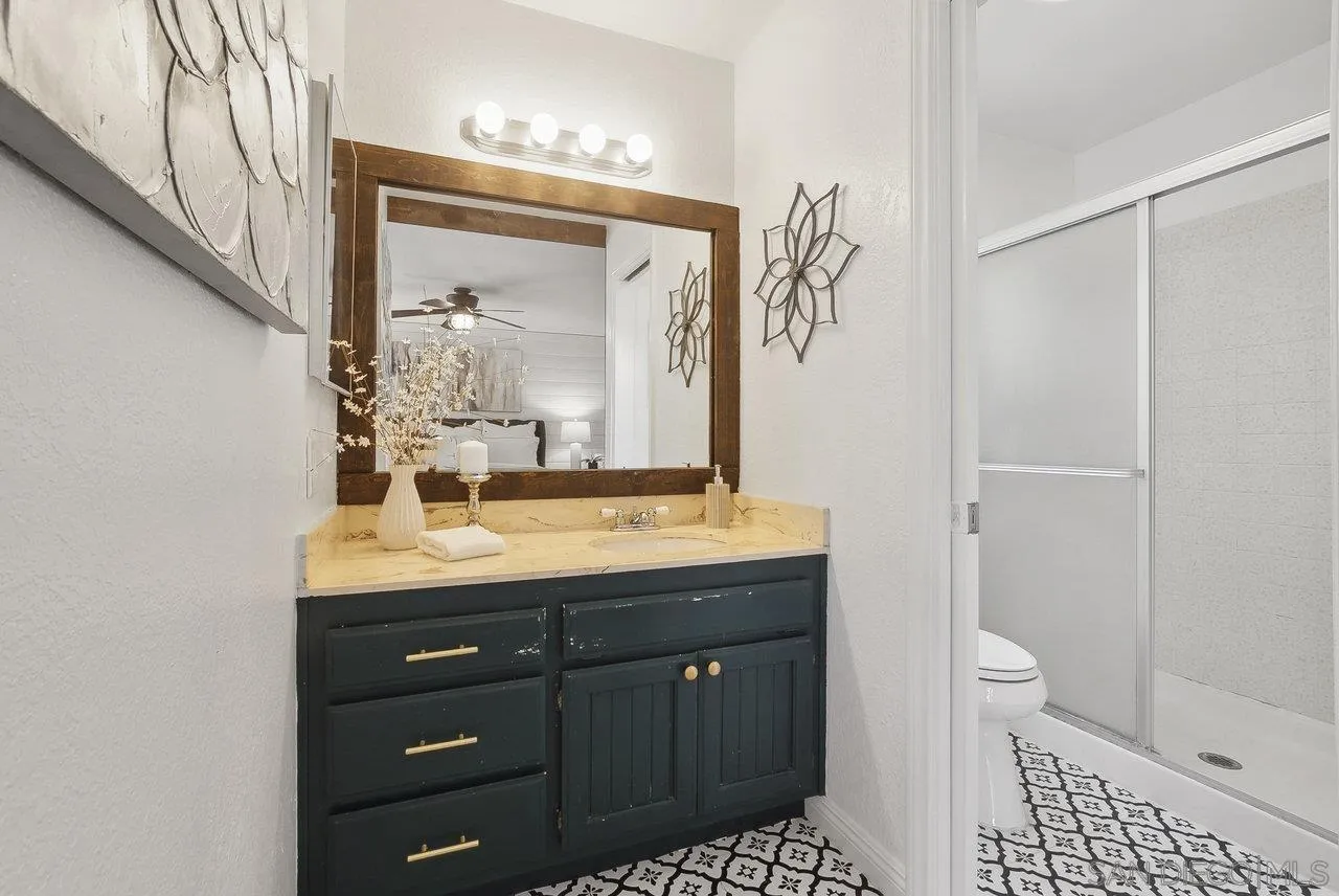 1369 Friends Way Fallbrook, CA 92028 - Photo 14 of 29 a bathroom with a granite countertop sink a toilet and a mirror