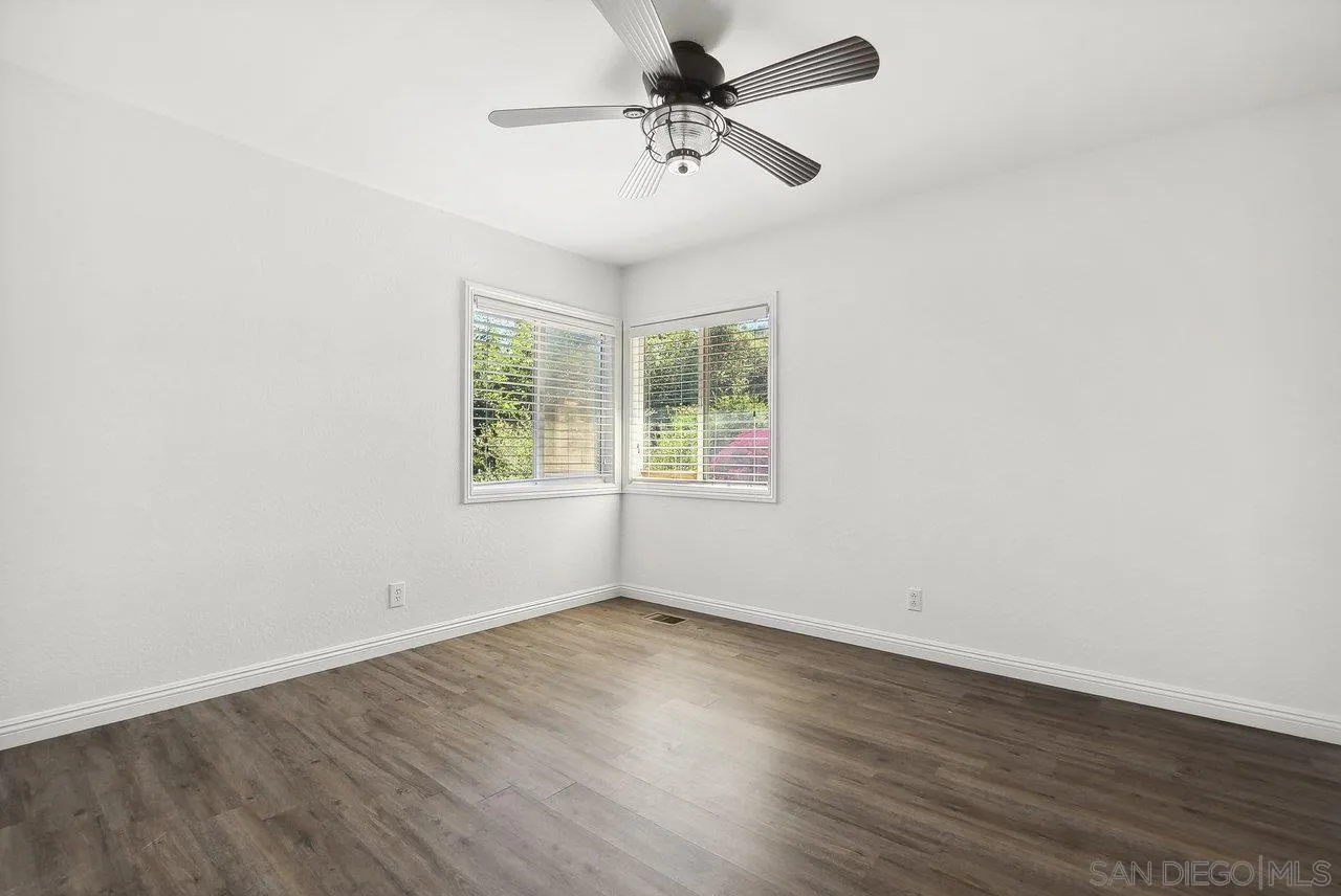 1369 Friends Way Fallbrook, CA 92028 - Photo 16 of 29 an empty room with wooden floor ceiling fan and windows