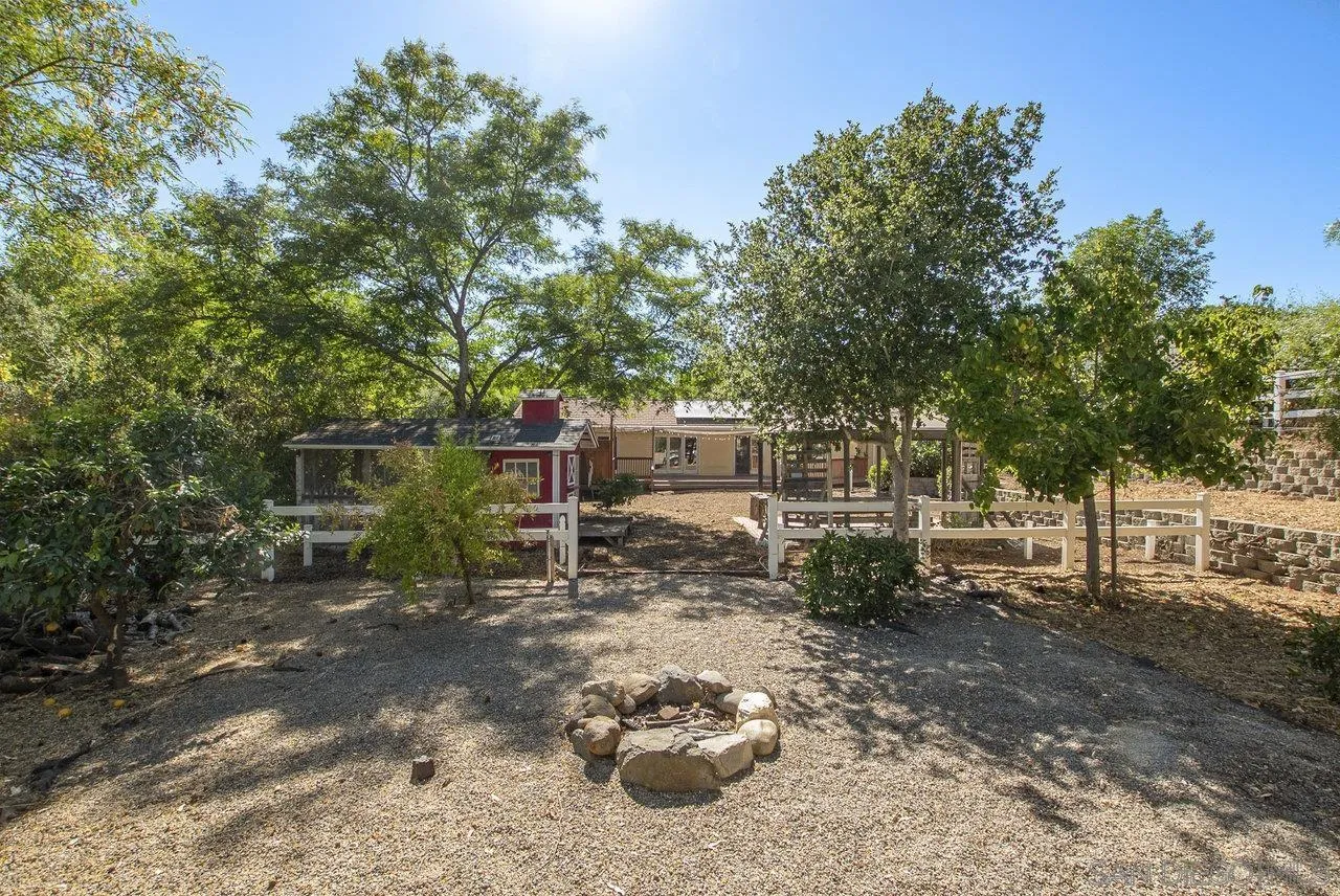1369 Friends Way Fallbrook, CA 92028 - Photo 18 of 29 a view of a backyard with table and chairs and a large tree