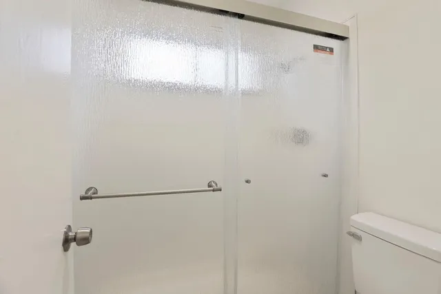 a white toilet sitting next to a shower