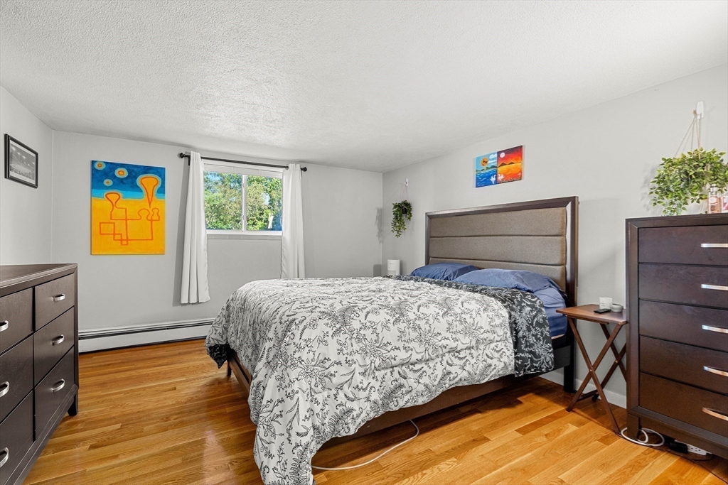 24 Westgate Road, Unit 2 Boston, MA 02467 - Photo 11 of 21 a bedroom with a bed and wooden floor