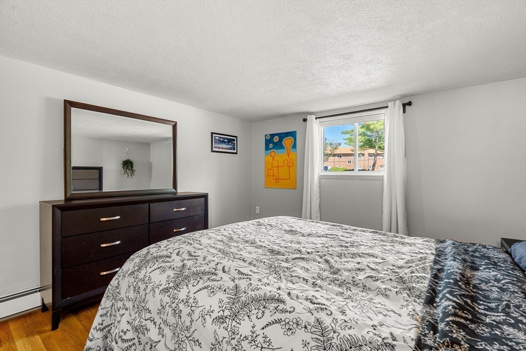 24 Westgate Road, Unit 2 Boston, MA 02467 - Photo 15 of 21 a bedroom with a bed and a dresser