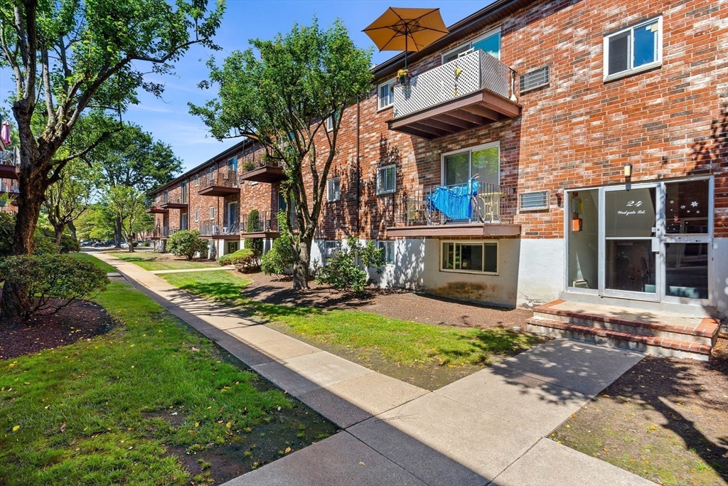 24 Westgate Road, Unit 2 Boston, MA 02467 - Photo 20 of 21 a front view of a house with a yard table and chairs