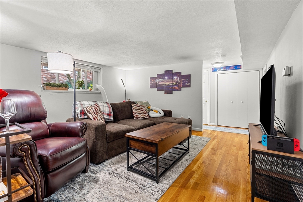 24 Westgate Road, Unit 2 Boston, MA 02467 - Photo 2 of 21 a living room with furniture a flat screen tv and a floor to ceiling window