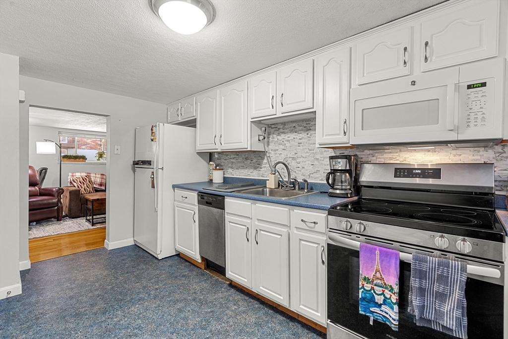 24 Westgate Road, Unit 2 Boston, MA 02467 - Photo 6 of 21 a kitchen with stainless steel appliances granite countertop a stove and a refrigerator