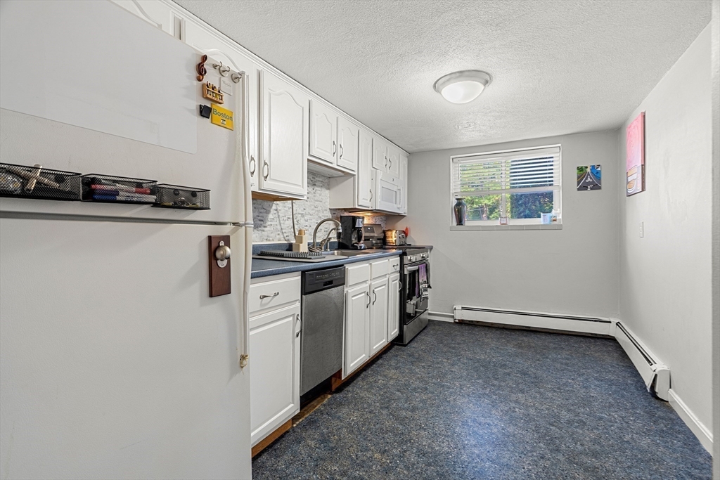 24 Westgate Road, Unit 2 Boston, MA 02467 - Photo 7 of 21 a kitchen with stainless steel appliances a sink a stove a microwave a refrigerator a window