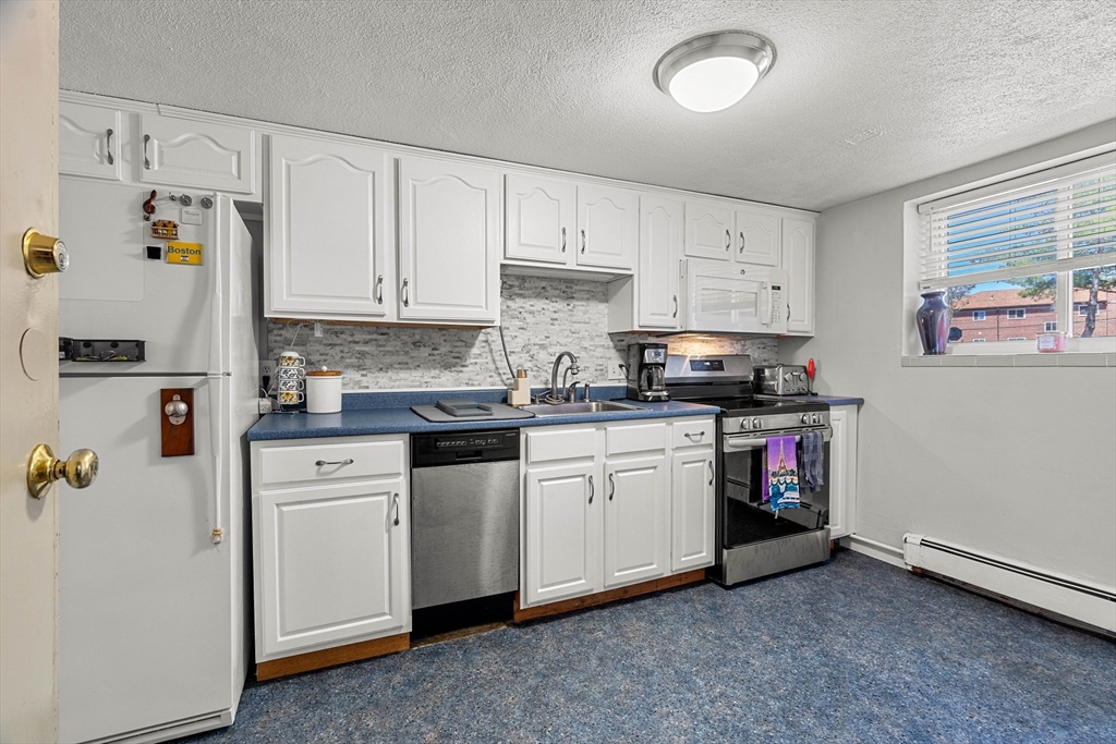 24 Westgate Road, Unit 2 Boston, MA 02467 - Photo 8 of 21 a kitchen with granite countertop white cabinets and white appliances
