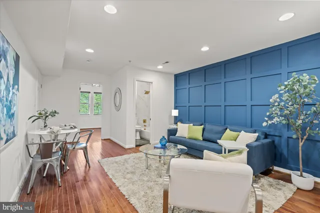 a living room with furniture and a wooden floor