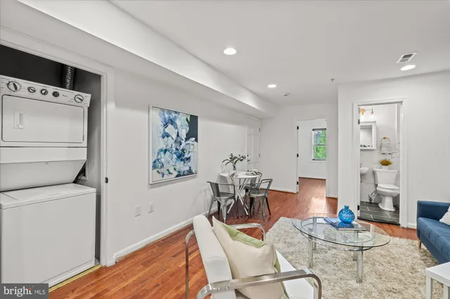a living room with furniture and a dining table with wooden floor