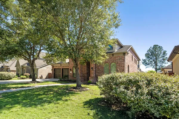 a view of a house with a yard and large tree