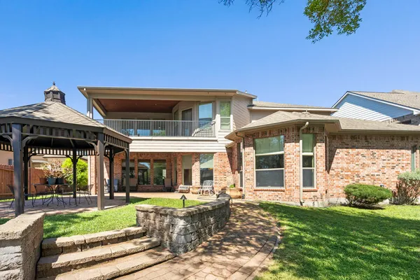 a view of a house with a big yard and large trees