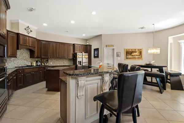 a kitchen with a stove cabinets and chairs
