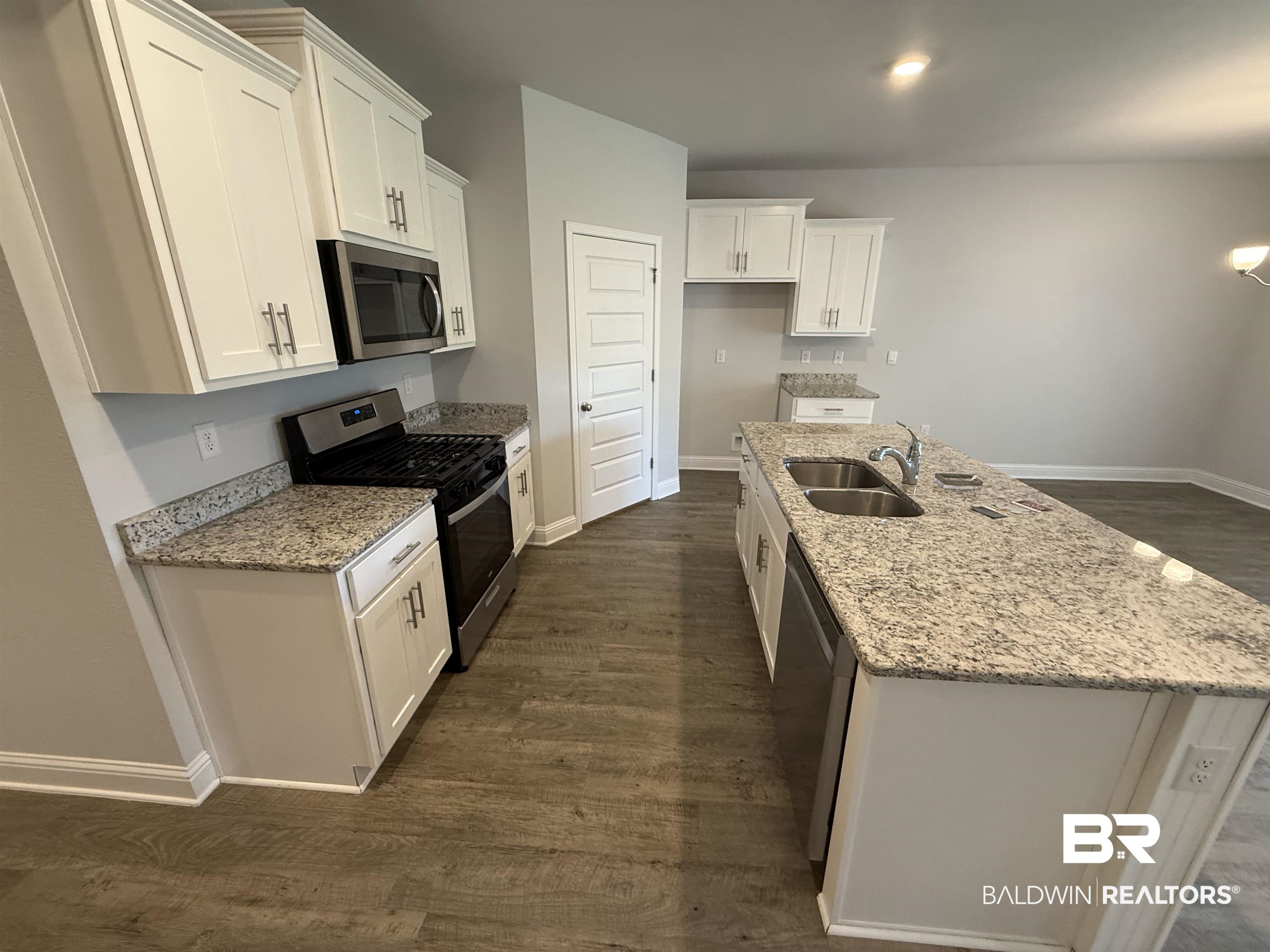 23247 Lieutenant Avenue Foley, AL 36535 - Photo 21 of 47 Kitchen featuring an expansive island with a double basin sink, stainless steel dishwasher, and stone countertops