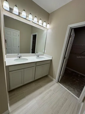 a bathroom with a double vanity sink and mirror