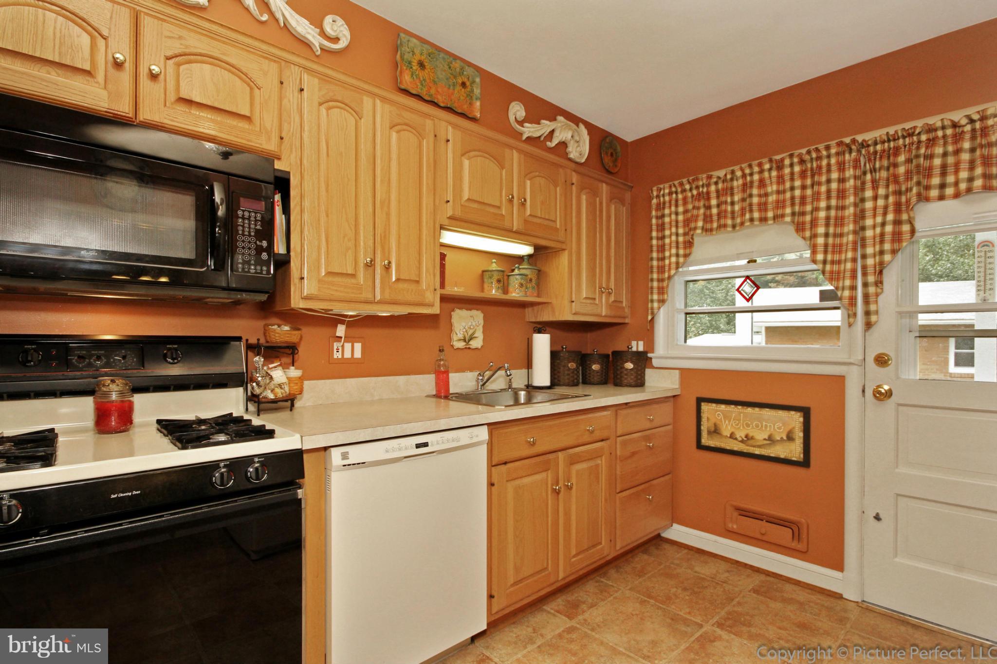9210 Summit Road Silver Spring, MD 20910 - Photo 14 of 29 a kitchen with stainless steel appliances a stove microwave and cabinets