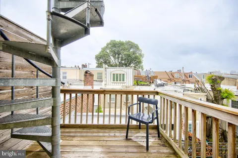 a view of a balcony with wooden chairs