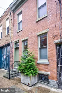 a view of a brick house with potted plants